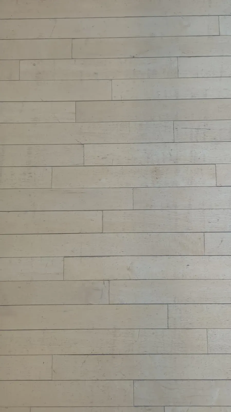 A wall of pale, narrow horizontal wood panelling.